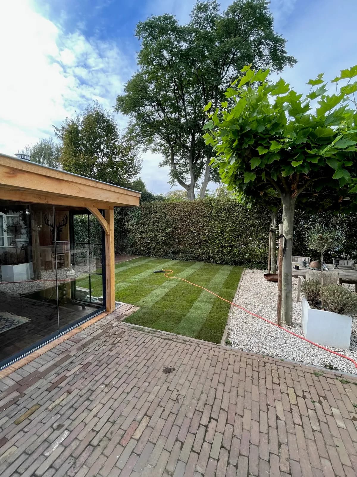 Klaar: dezelfde tuin met een nieuw, strak gazon, op dezelfde dag